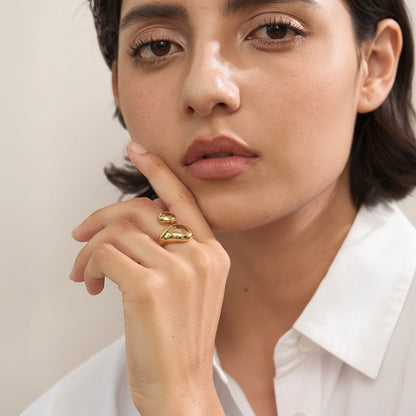 PRO RAY ELORIA sculptural open ring with smooth organic curves and bold polished gold silhouette, worn by a model.