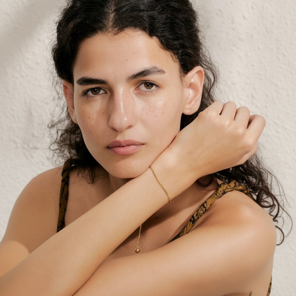 PRO RAY AELORA delicate gold chain bracelet with polished bead accent on a woman's wrist.