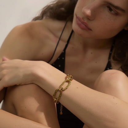 PRO RAY AUREVA gold chain bracelet with textured sculptural links and adjustable clasp. Model wears on wrist.