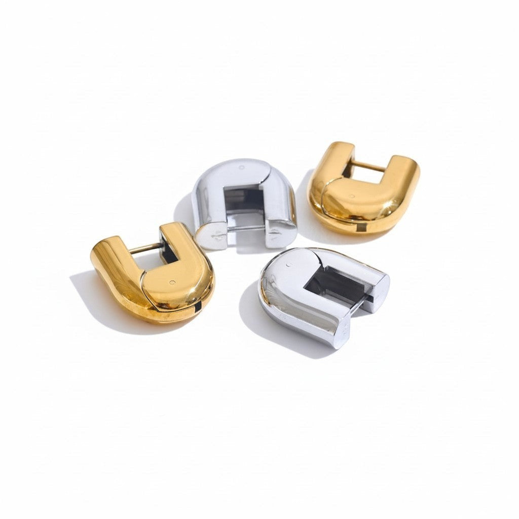 PRO RAY ELARA sculptural hoop earrings in gold and silver finishes, 20mm diameter.