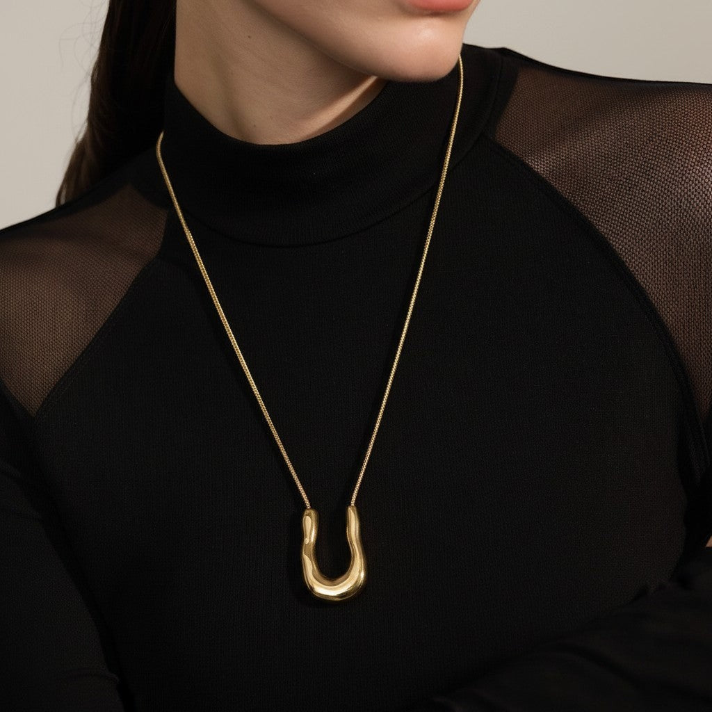 PRO RAY ELORA gold sculptural pendant necklace with organic curves on a fine chain.