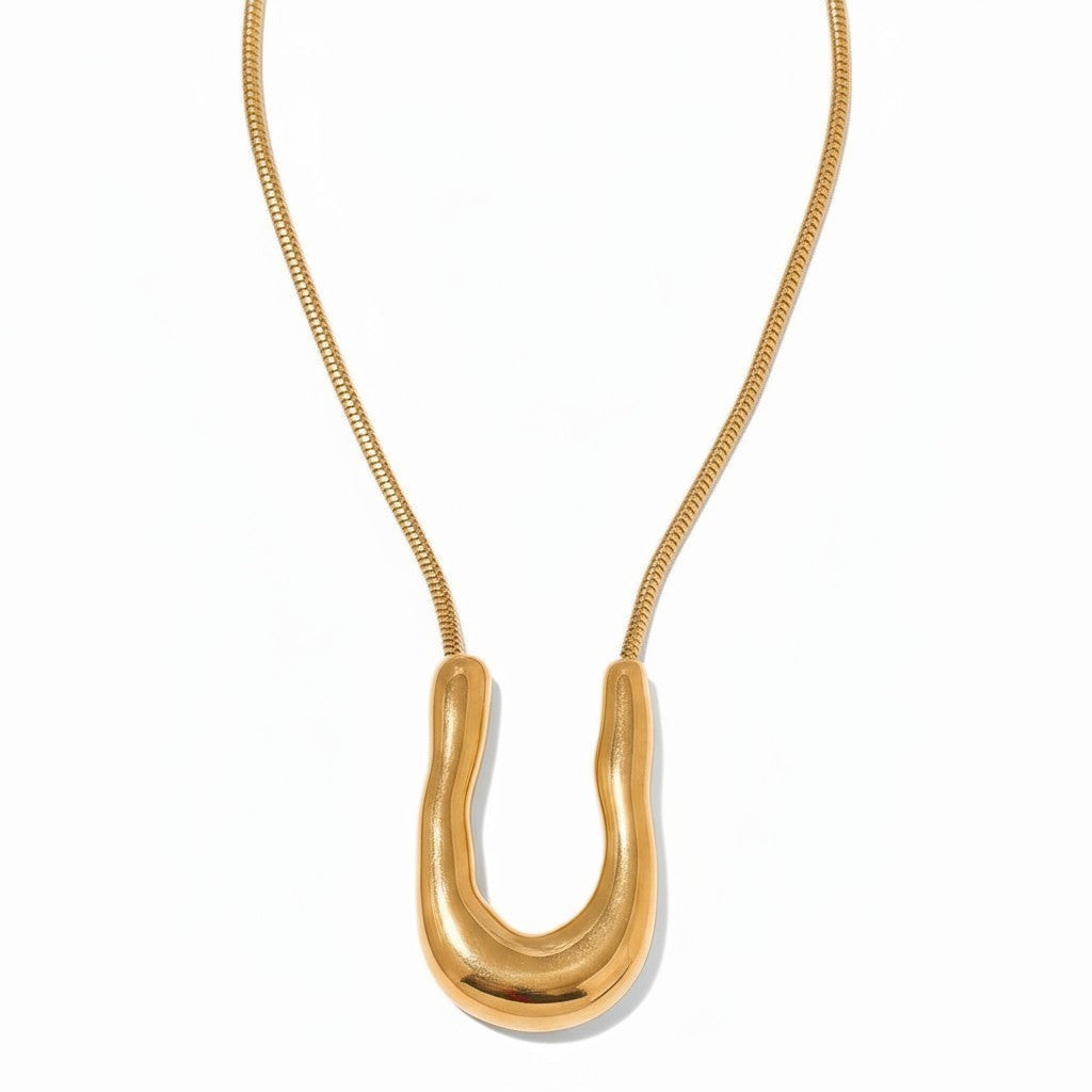 PRO RAY ELORA sculptural gold-tone pendant necklace with fluid organic curves and snake chain.