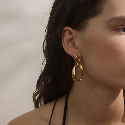PRO RAY ORINA sculptural open oval drop earrings in polished gold finish. Modern elegance.