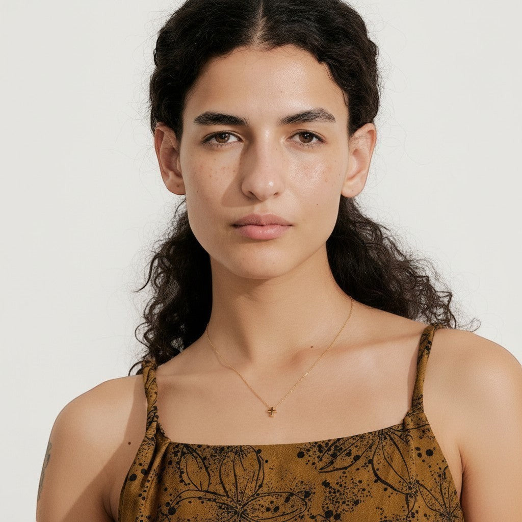 PRO RAY NAYLA delicate gold cross pendant necklace on a thin chain, worn by a model.