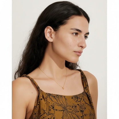 PRO RAY NAYLA delicate gold cross pendant necklace on a thin chain, worn by a model.