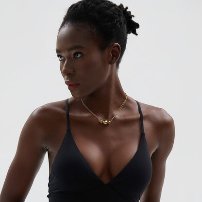 PRO RAY gold NOVA necklace with three spherical beads on a delicate double chain, worn by a model.