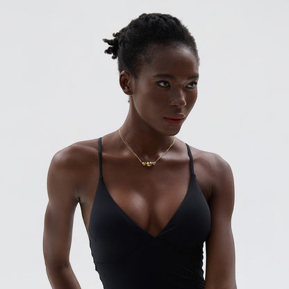 PRO RAY gold NOVA necklace with three spherical beads on a delicate chain, worn by a model.