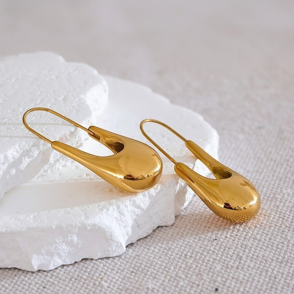 PRO RAY NYRA sculptural drop hoop earrings in polished gold finish, elongated silhouette, 48mm length.