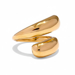 PRO RAY SERAVIA Ring: A bold, sculptural gold-tone ring with flowing curved lines and a smooth polished finish. Open silhouette.