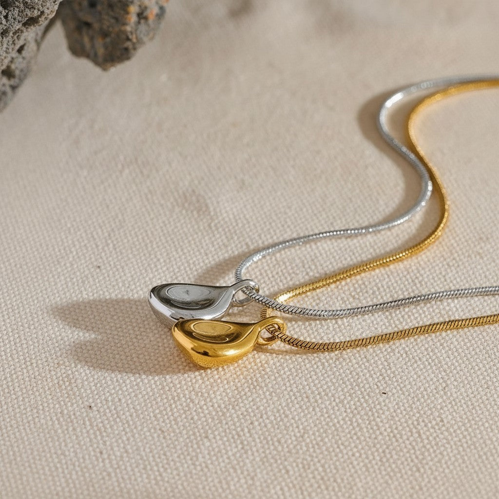 PRO RAY TELYA sculptural pendant necklace in gold and silver finishes with soft flowing curves.