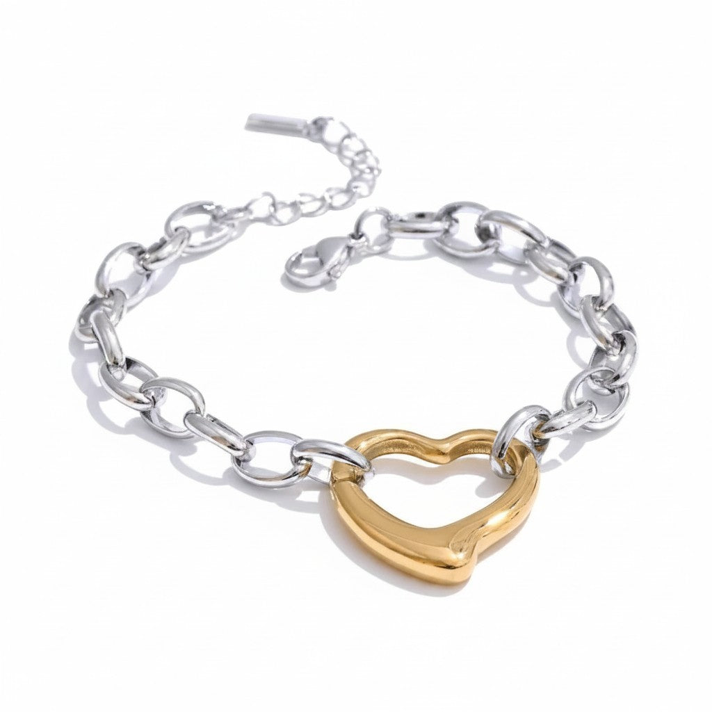 PRO RAY VELORA sculptural heart bracelet with bold silver chain detailing and gold heart charm. Modern statement jewelry.