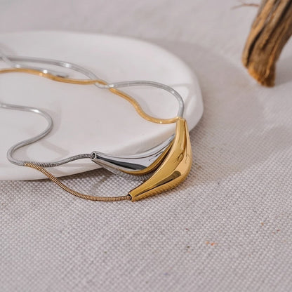 PRO RAY VIRA necklace with a fluid sculptural pendant in gold and silver tones. Snake chain.