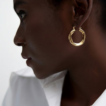 PRO RAY ZARIA gold twisted hoop earrings with a sculptural silhouette, 31mm diameter.
