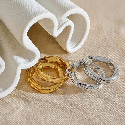 PRO RAY ZARIA gold and silver twisted hoop earrings with sculptural silhouette, 31mm diameter.